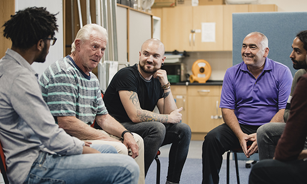 Image shows adult service users in a group support meeting