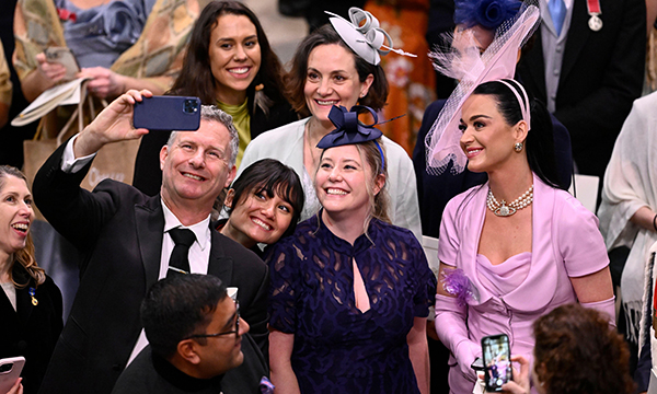 Nurse Emily Regan, flanked by comic Adam Hills and singer Katy Perry at the coronation