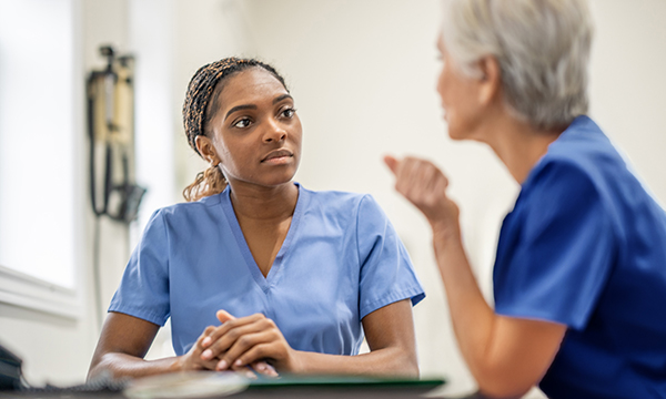 Nursing staff well-being: two nurse colleagues sit and discuss workplace issues
