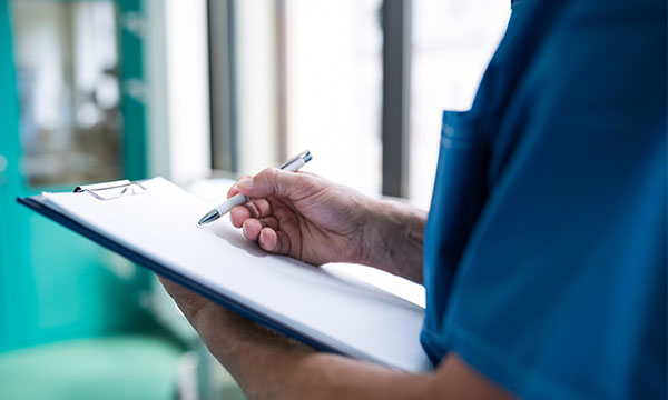 Picture shows a nurse writing on a clipboard. FtP panel heard a consultant struggled to read figures written by the nurse