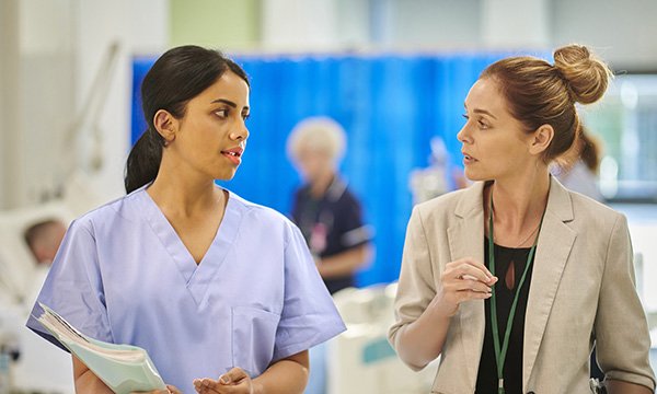 Microaggressions in nursing: young nurse and non-uniform colleague in a serious discussion
