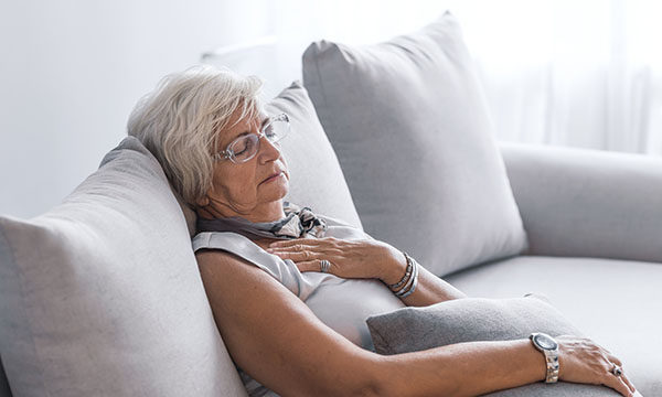 woman sits slumped on a sofa