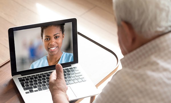 Primary care nurse carrying out a remote consultation via video on a laptop