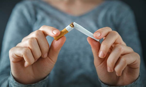 Picture shows someone breaking a cigarette in half. During COVID-19 and for other health reasons, now is a good time to quit smoking