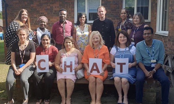 Clinical lead Melanie Pettitt with 12 fellow members of the award-winning Care Home Assessment Team in North London, four holding a CHAT sign