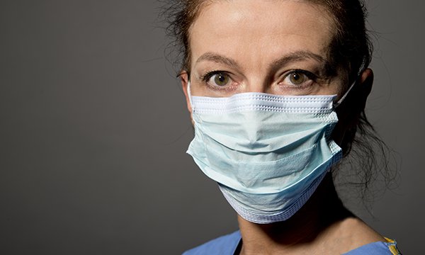 A nurse wearing a face mask and scrubs