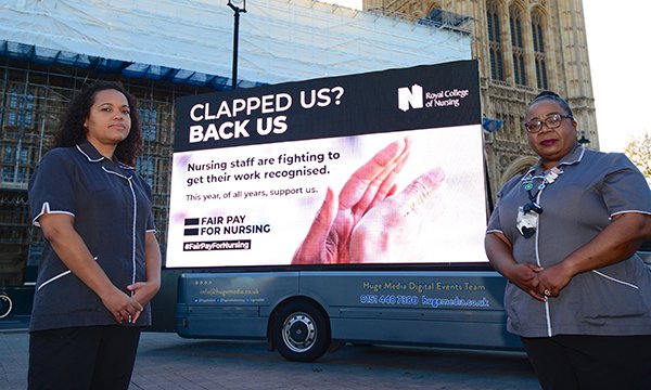 RCN members Grace Milner (left) and Kafeelat Adekunle with the new 'Clapped us? Back us' billboard