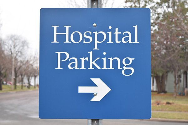 Sign that reads 'hospital parking', with an arrow below