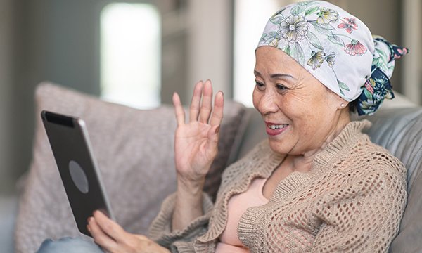 Picture shows a rehab patient looking at a tablet computer