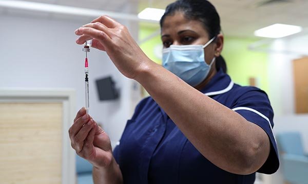 Nurse prepares to administer the COVID-19 vaccine to a patient