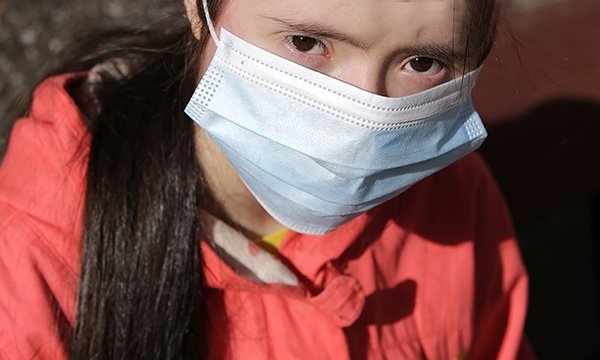 A woman with learning disabilities wearing a mask to protect against COVID-19