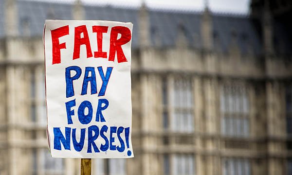 Picture shows a placard demanding fair pay for nurses, with houses of parliament in the background 