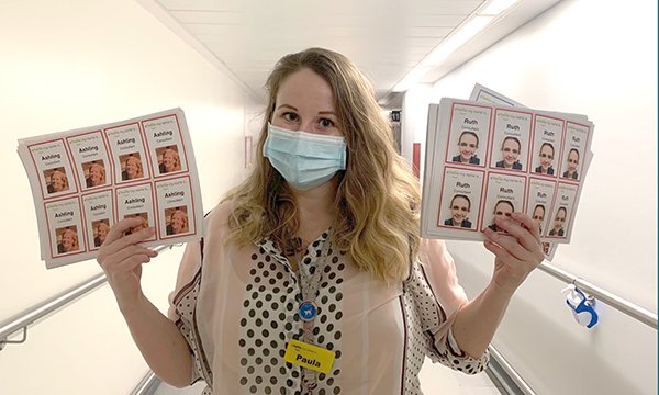 Paula Ryeland of Whittington Health holds staff picture badges designed to put patients at their ease during the coronavirus pandemic