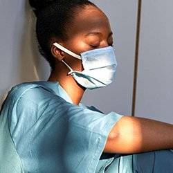 An exhausted emergency department nurse in mask