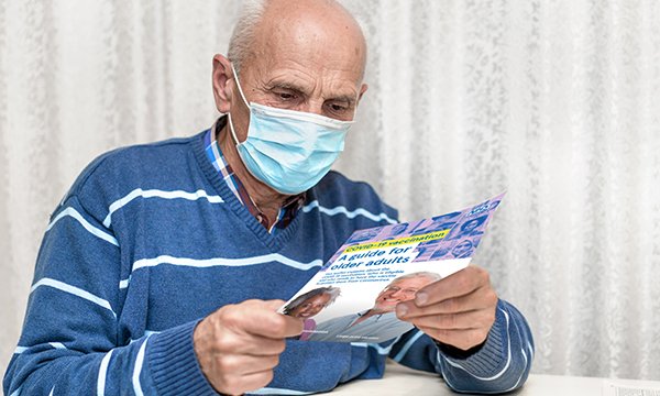A patient reading information about the COVID-19 vaccination programme