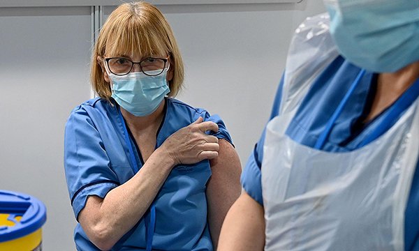 A nurse receives her first COVID-19 vaccination at the NHS Louisa Jordan Hospital in Glasgow