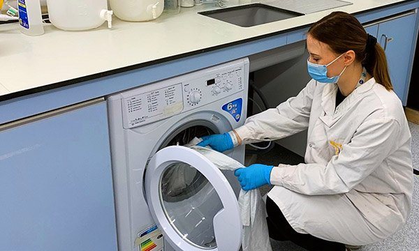 A researcher washing uniforms as part of the study