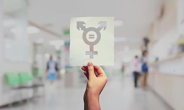 Image of a person holding gender symbols