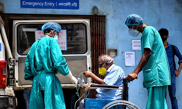 Medics with a patient in a wheelchair in Kolkata, India on 27 April