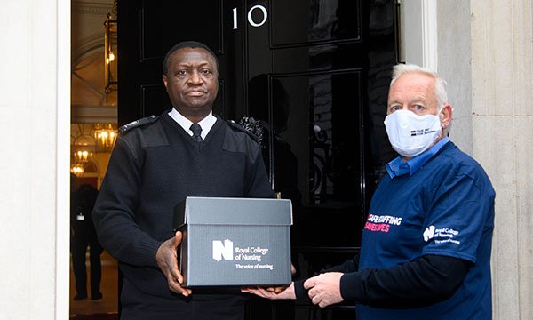 Graham Revie, chair of the RCN trade union committee hands the Fair Pay for Nursing petition to security at Downing Street today. 