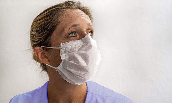 Picture shows a female medic wearing a mask and looking perplexed
