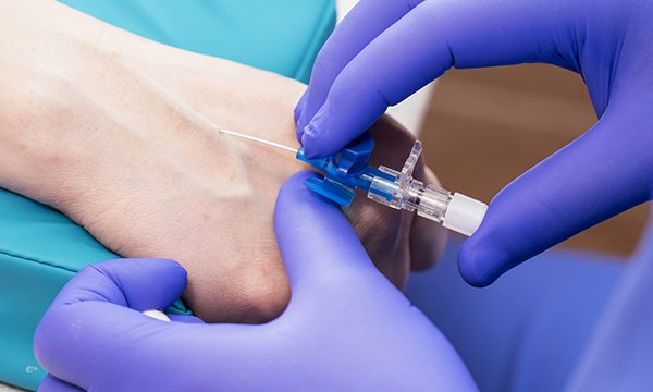 Picture shows an injection being given by someone wearing gloves