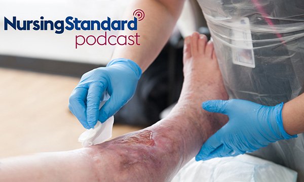 Nurse with gloved hands cleanses a patient's leg ulcer