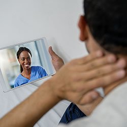 A nurse and patient conducting a digital consultation via tablet