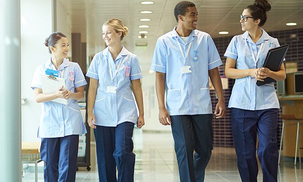 A group of four young nurses walking in a hospital