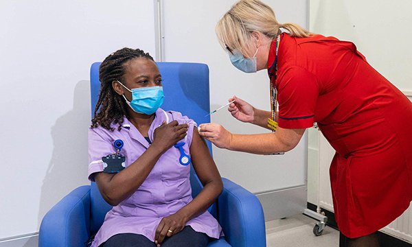 Picture shows a female nurse receiving the COVID-19 booster vaccination