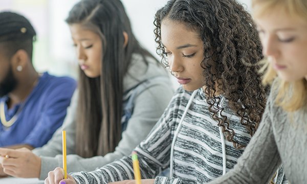 Photo of four young people taking a written test