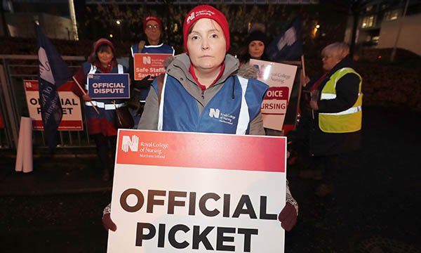 Photo of an RCN member holding an official picket sign