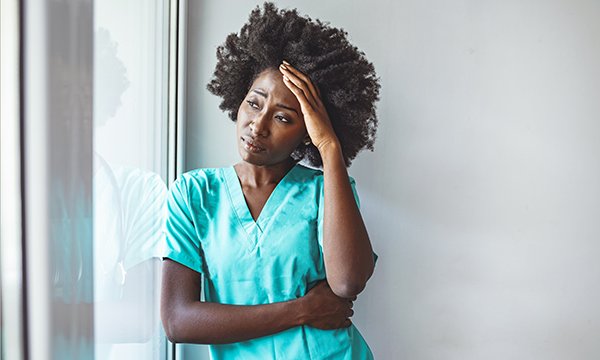 Photo of a nurse looking stressed and upset