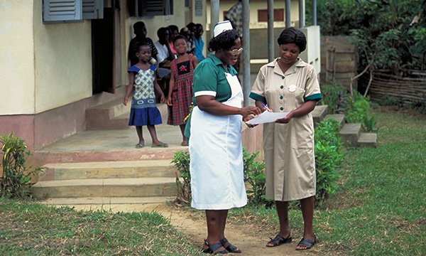 A nurse talks to an administrator at a health clinic in western Ghana