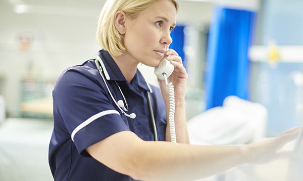 A nurse speaking on a landline phone