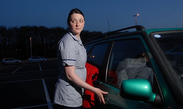Photo of nurse looking nervous in a hospital car park, illustrating a story about NHS staff safely