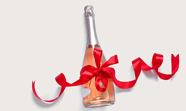 A bottle of sparking wine wrapped in red ribbon
