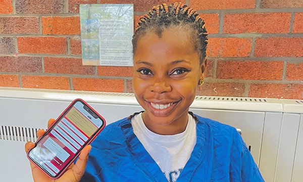 Nurse from Nigeria Virginia Enyidede shows her bus pass app on her phone