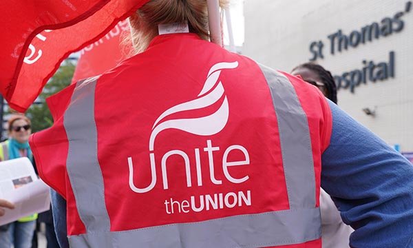 Photo showing someone wearing a Unite the union jacket on a picket line outside St Thomas' Hospital