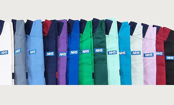 A photo of 14 differently coloured NHS uniforms