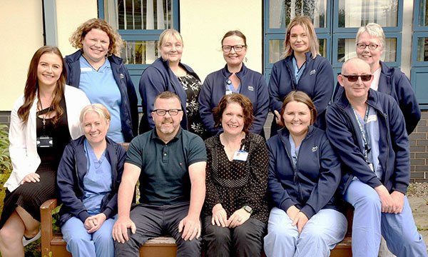 Members of the Highland Urology Nursing Team, winners of the Chief Nursing Officer’s award, seated and standing outside their workplace