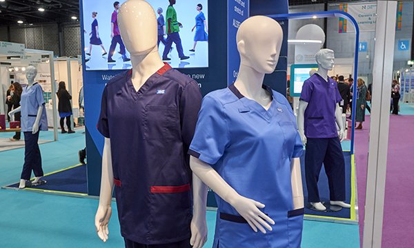 Two uniforms displayed on mannequins - a female one in royal blue and a male one in deep purple dark purple