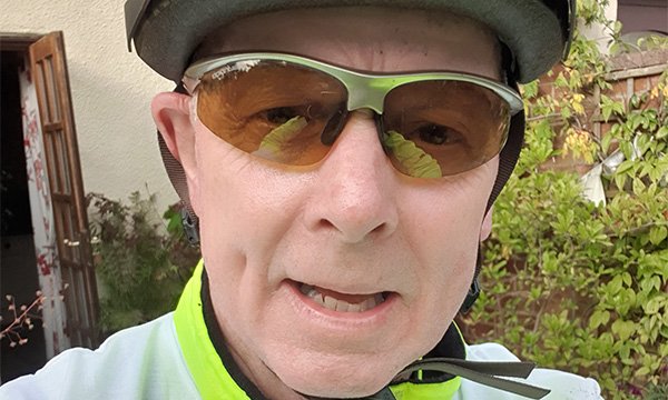 A selfie by Ian Clifford, wearing cycling gear, sunglasses and helmet 