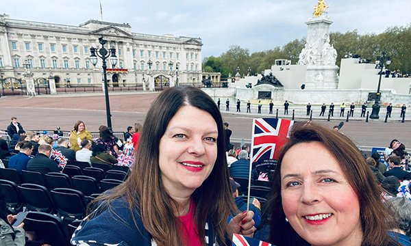 Nurses Jane Radice and Charlotte Durham hold union flags with Buckingham Palace and grandstand seats in background