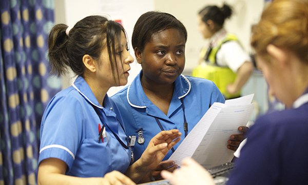 Nurses checking documents and consulting each other