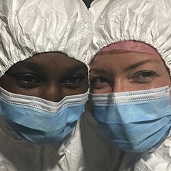 Picture shows a close up of two nurses wearing masks and other protective gear