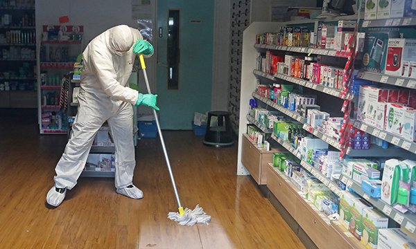 A worker in protective clothing cleaning the County Oak Medical Centre in Brighton