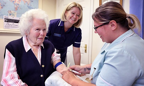 Practice nurse manager Emma Williamson oversees healthcare assistant Victoria Larkman as she takes a blood sample. Ms Williamson studied her practice’s leg ulcer care and devised a pathway that improved healing, reduced spending and freed nurses’ time.