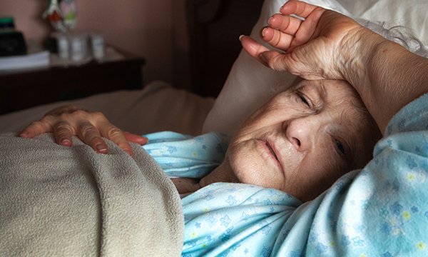 Picture shows an older woman lying in bed looking unwell. Follow Public Health England advice and also be aware that older patients can become suddenly unwell, says advanced clinical practitioner Neal Aplin.