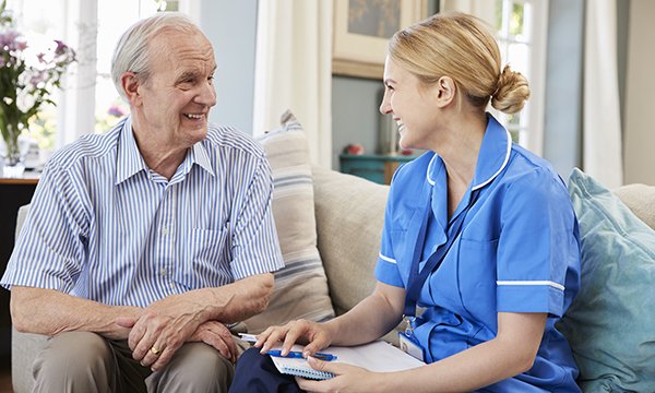 Picture shows a nurse doing a medicines review with an older man. A nurse-led monitoring tool that checks for adverse drug reactions could help curb overuse of mental health medicines in care homes, researchers say.